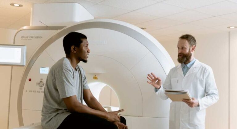 A white radiological technician consult with a Black patient after a scan